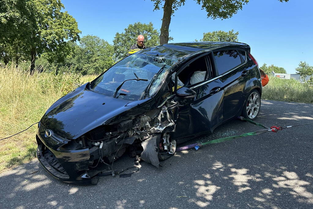 Auto belandt op de kop na botsing tegen boom