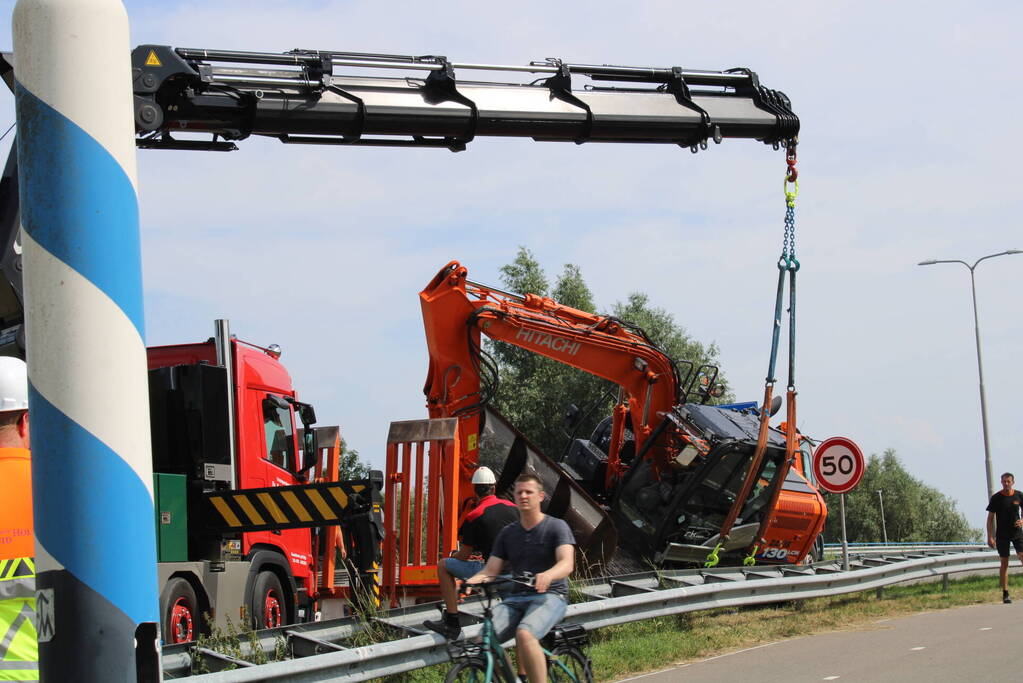 Graafkraan valt van dieplader