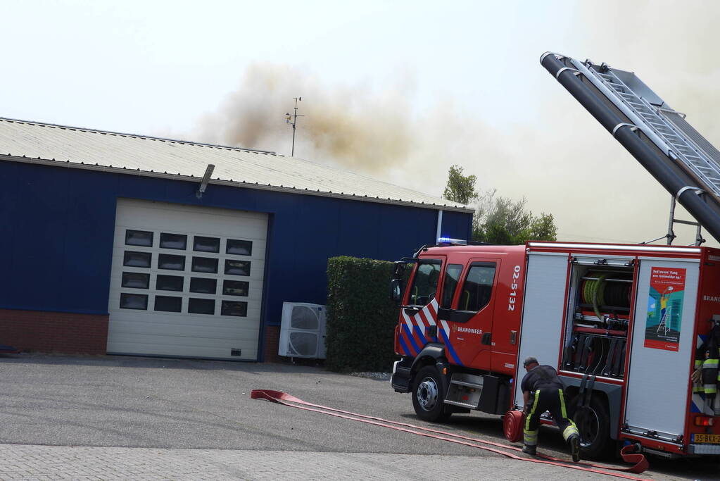 Grote brand in loods met komkommers en paprika's