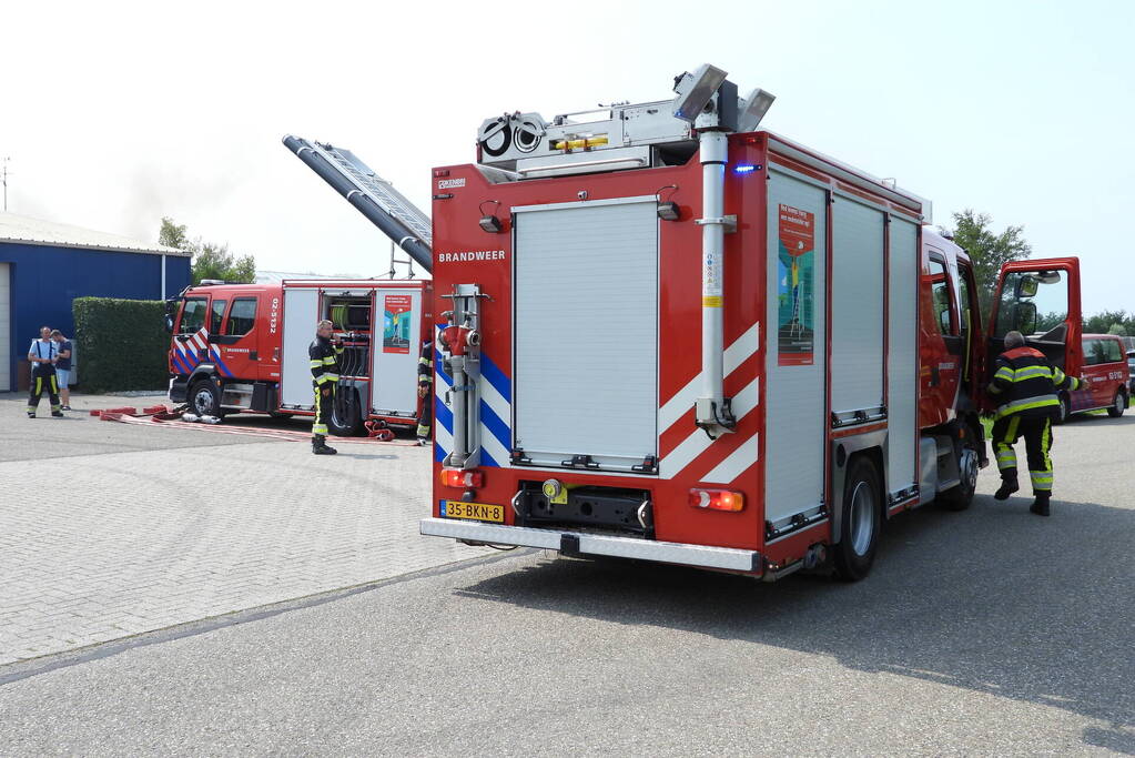 Grote brand in loods met komkommers en paprika's