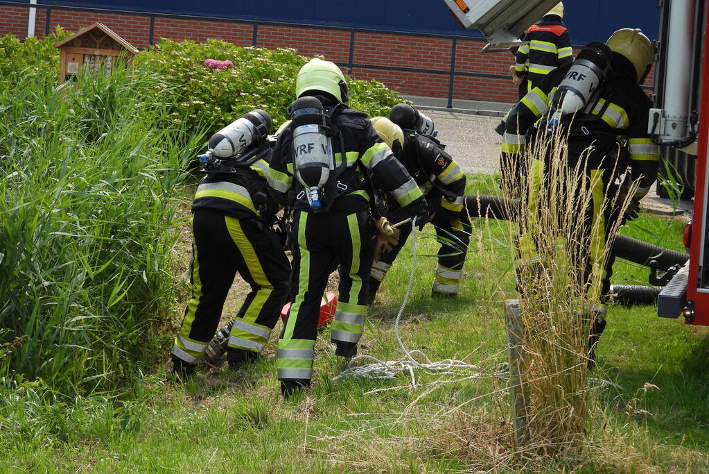 Grote brand in loods met komkommers en paprika's