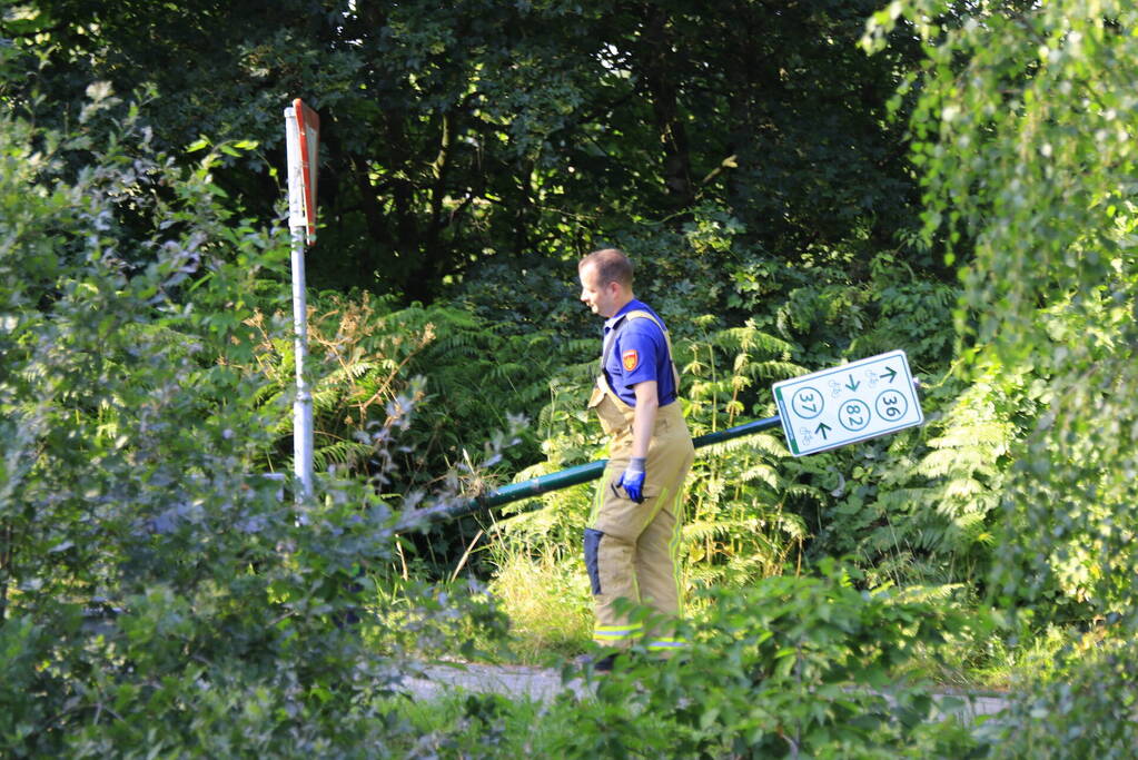 Brandweer haalt fiets en verkeersbord uit water