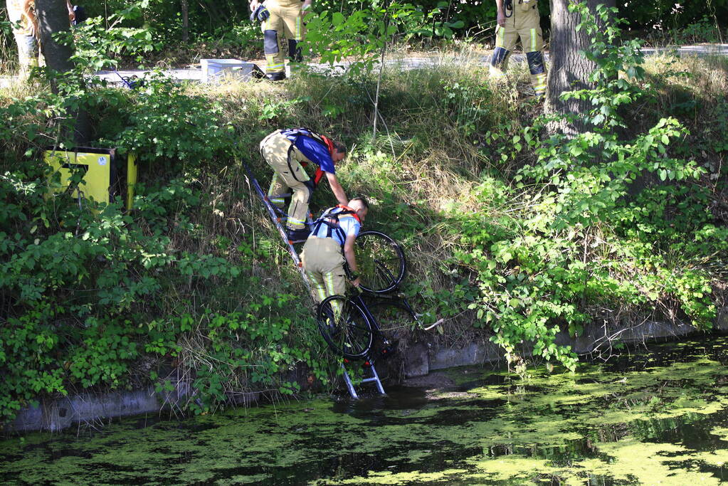 Brandweer haalt fiets en verkeersbord uit water