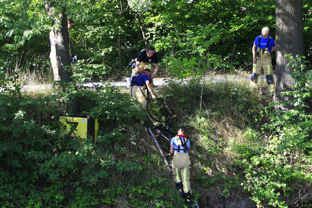 Brandweer haalt fiets en verkeersbord uit water