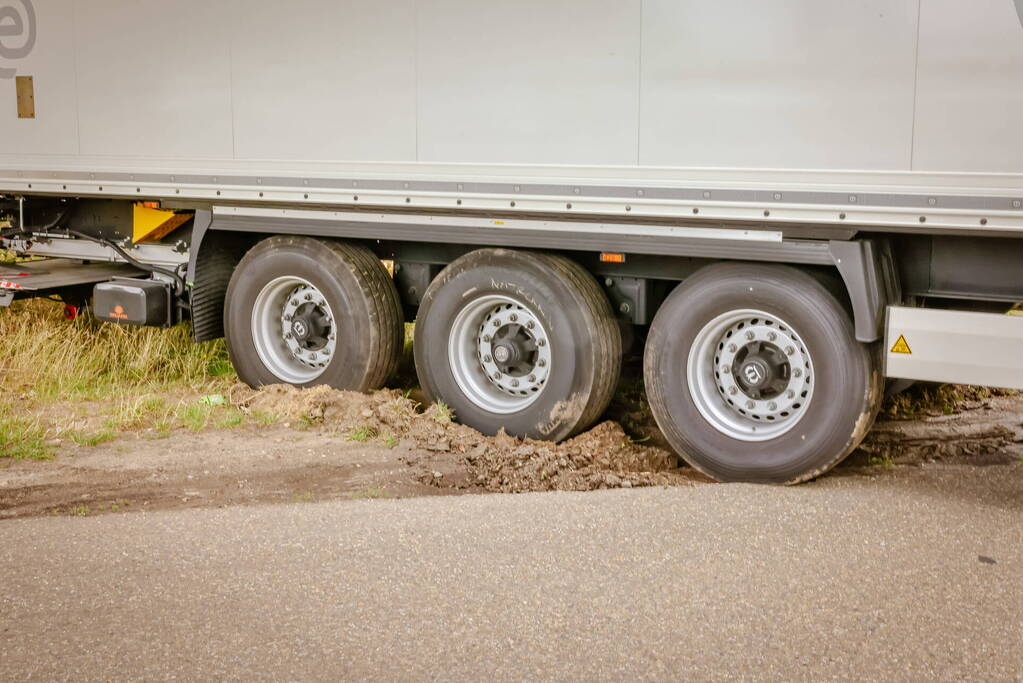 Vrachtwagenchauffeur rijdt zich vast na het keren