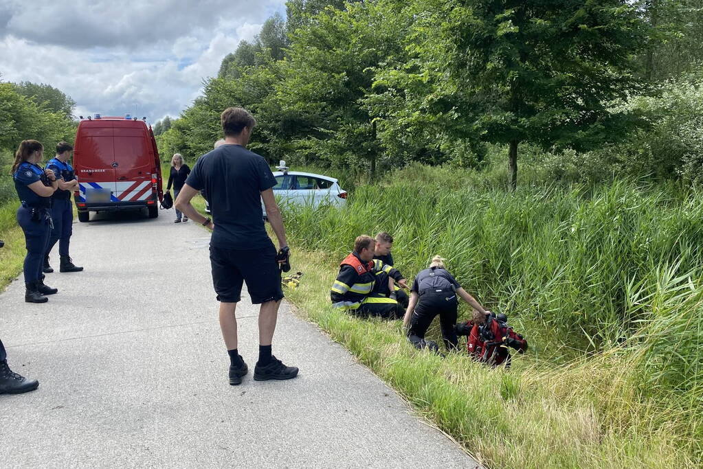 Vrouw rijdt met driewieler de sloot