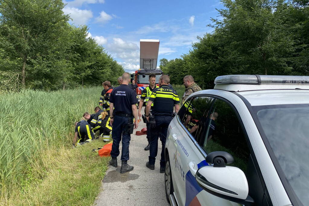 Vrouw rijdt met driewieler de sloot