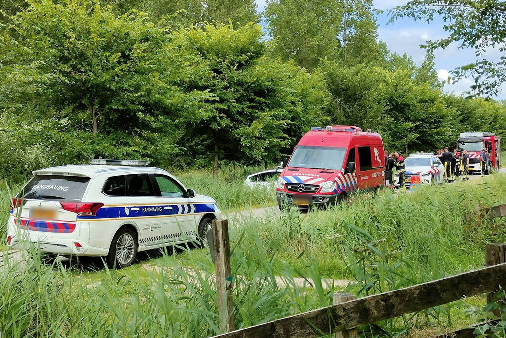 Vrouw rijdt met driewieler de sloot