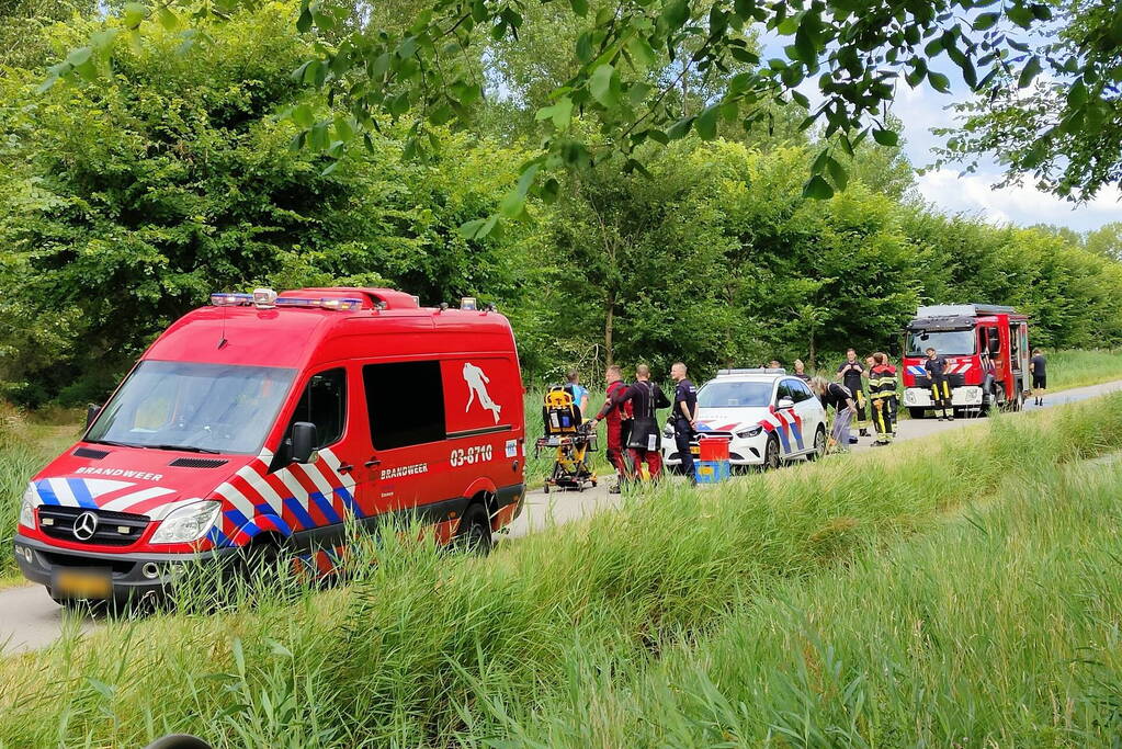 Vrouw rijdt met driewieler de sloot