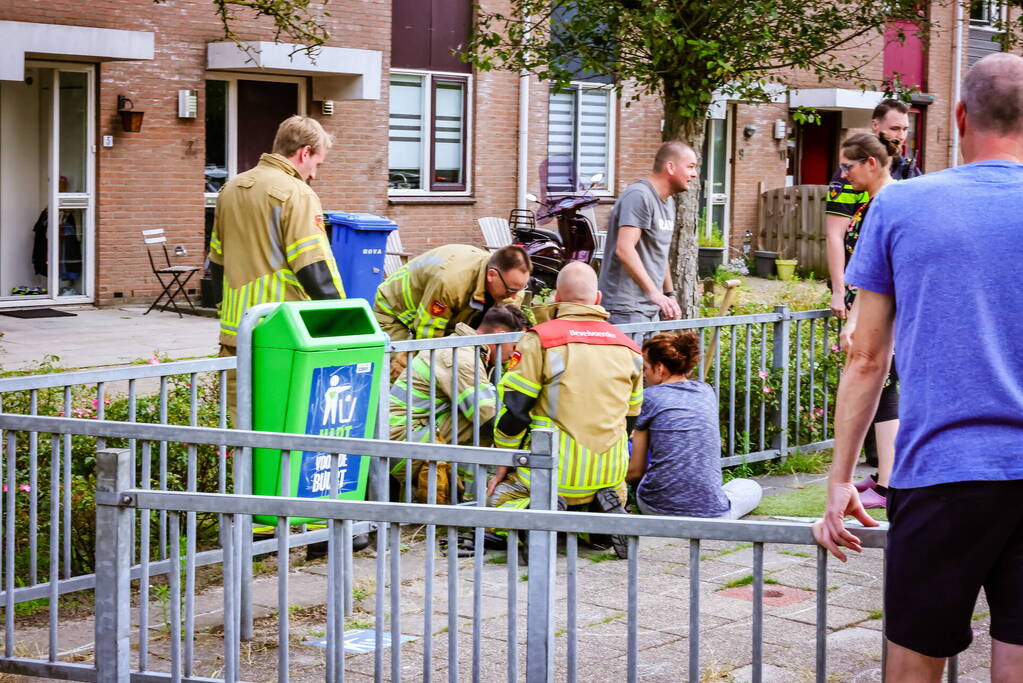 Kind met hoofd vast in hekwerk