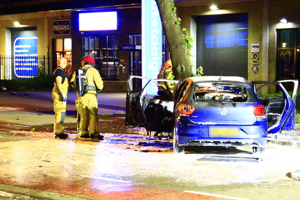 Auto in brand na frontale botsing tegen boom, twee gewonden