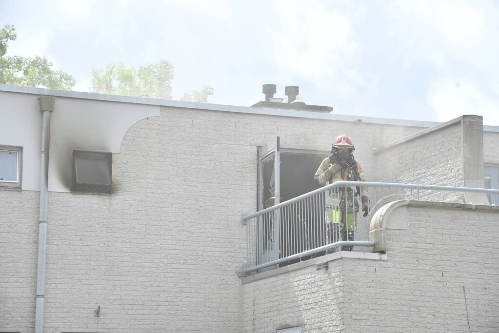 Zwarte rook uit woning door brand