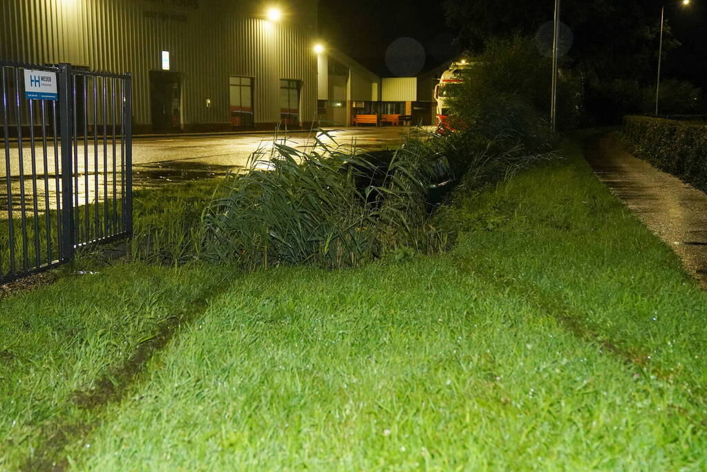 Auto glijdt de bocht uit in een sloot