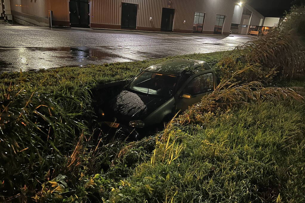 Auto glijdt de bocht uit in een sloot