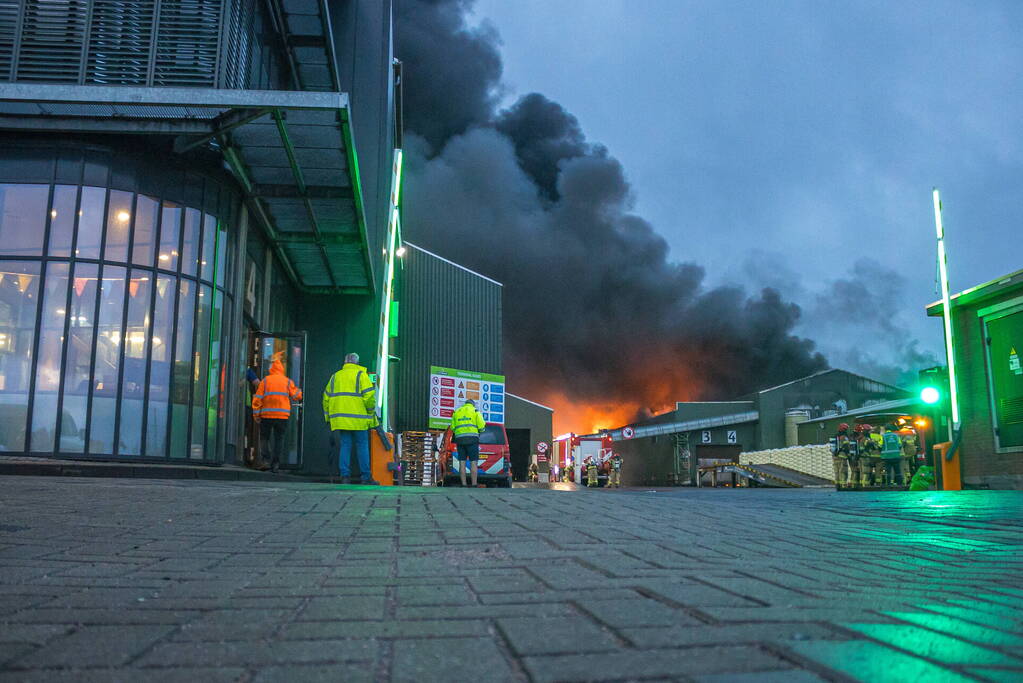 Zwarte rookpluimen boven havengebied door grote brand