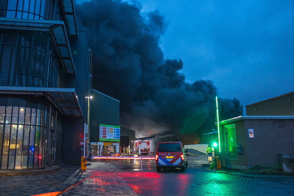 Zwarte rookpluimen boven havengebied door grote brand