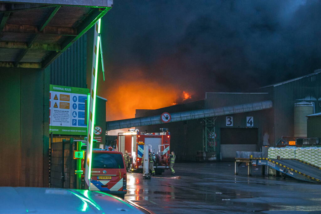 Zwarte rookpluimen boven havengebied door grote brand