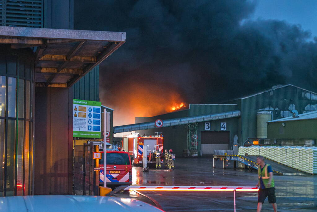 Zwarte rookpluimen boven havengebied door grote brand