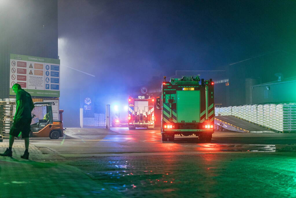 Zwarte rookpluimen boven havengebied door grote brand