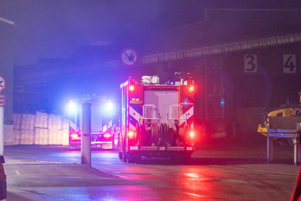 Zwarte rookpluimen boven havengebied door grote brand