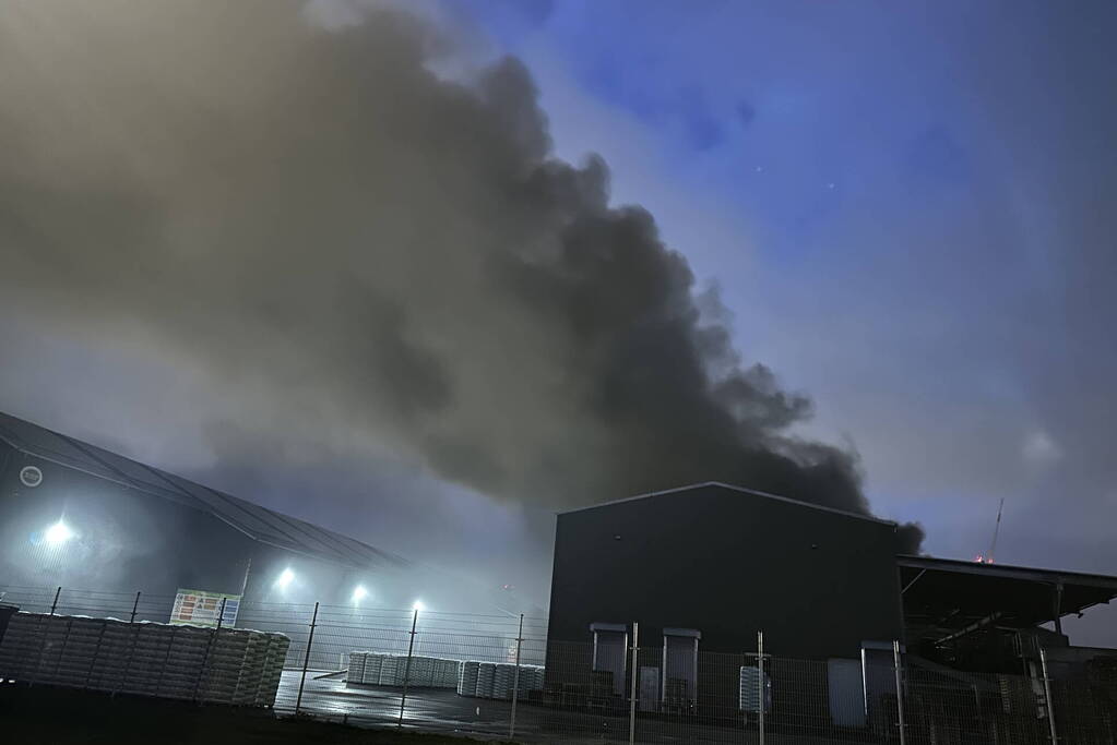 Zwarte rookpluimen boven havengebied door grote brand