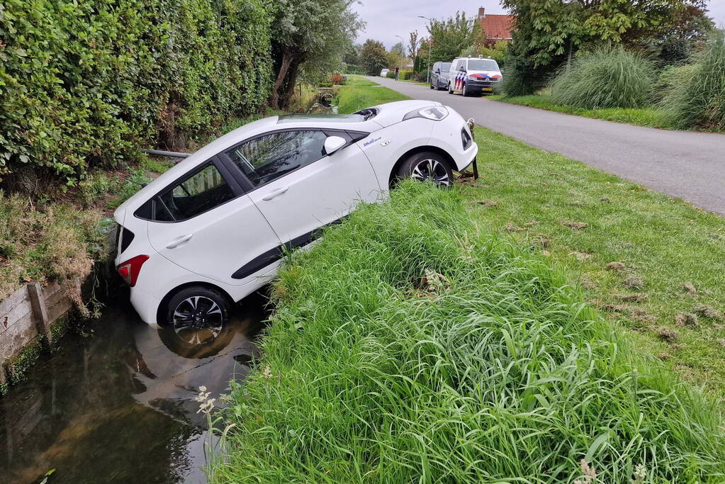 Auto rijdt achteruit de sloot in