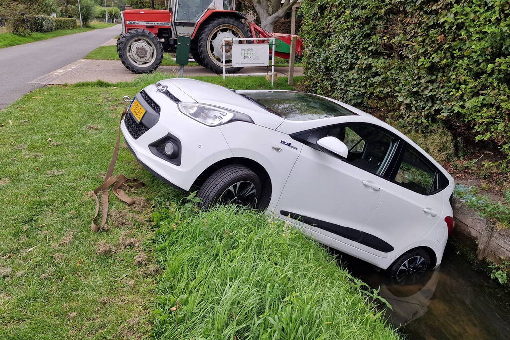 Auto rijdt achteruit de sloot in