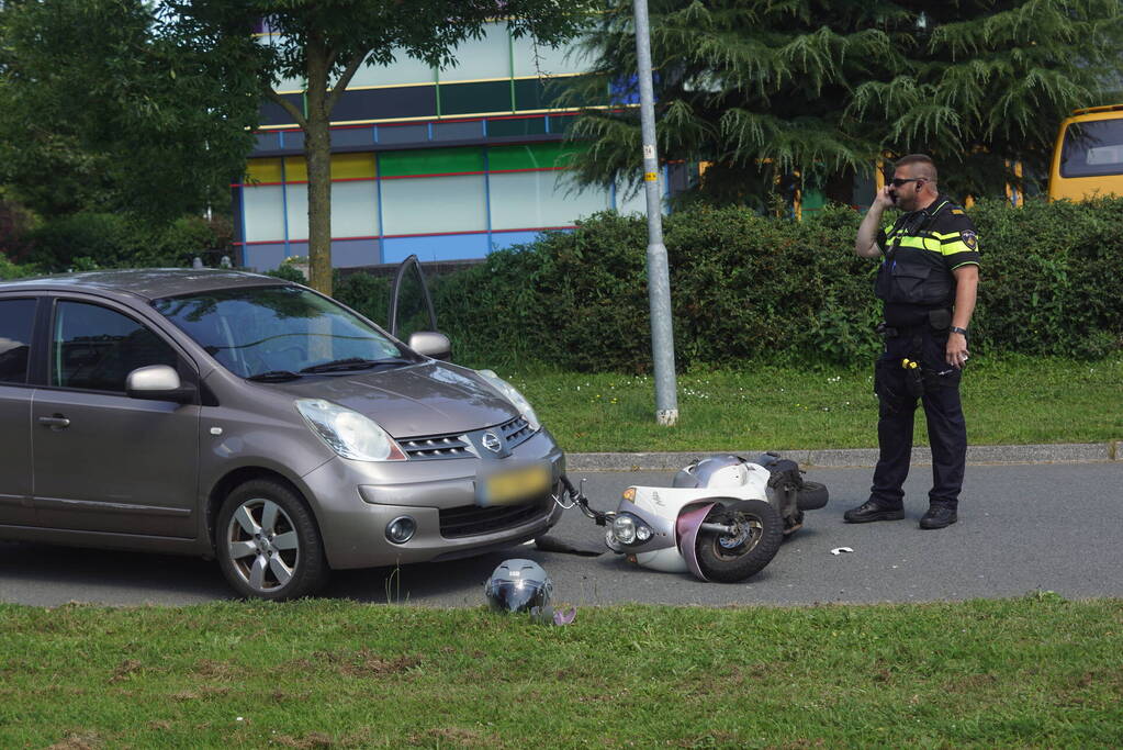 Automobilist en scooterrijder in botsing