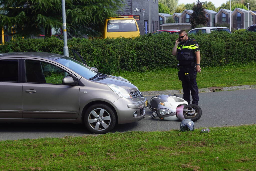 Automobilist en scooterrijder in botsing