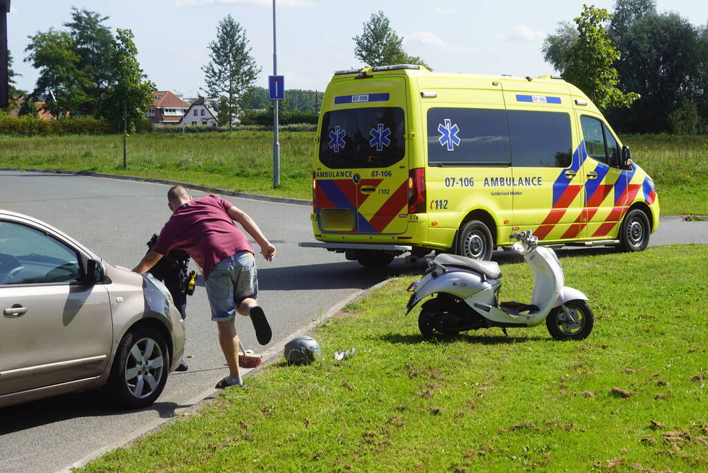 Automobilist en scooterrijder in botsing