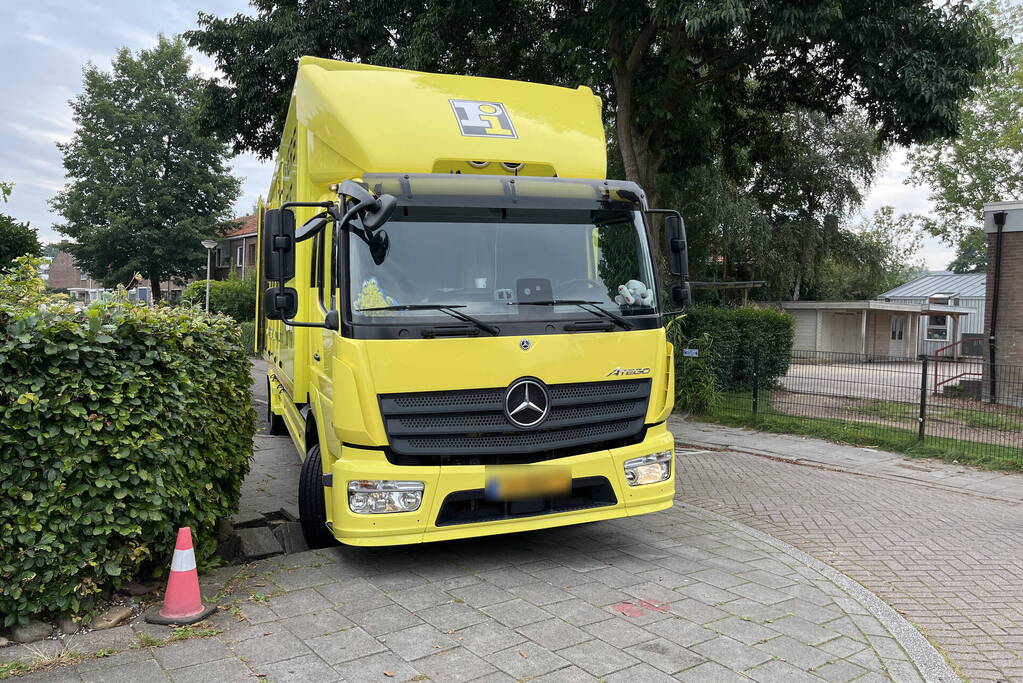 Vrachtwagen zakt weg in stoep