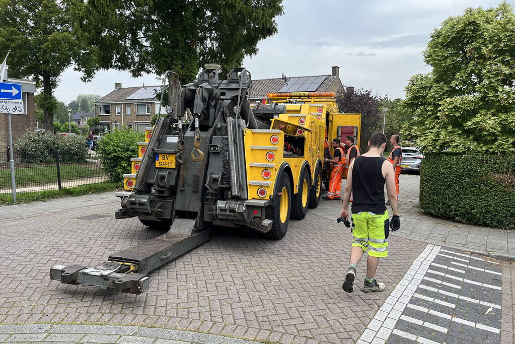 Vrachtwagen zakt weg in stoep