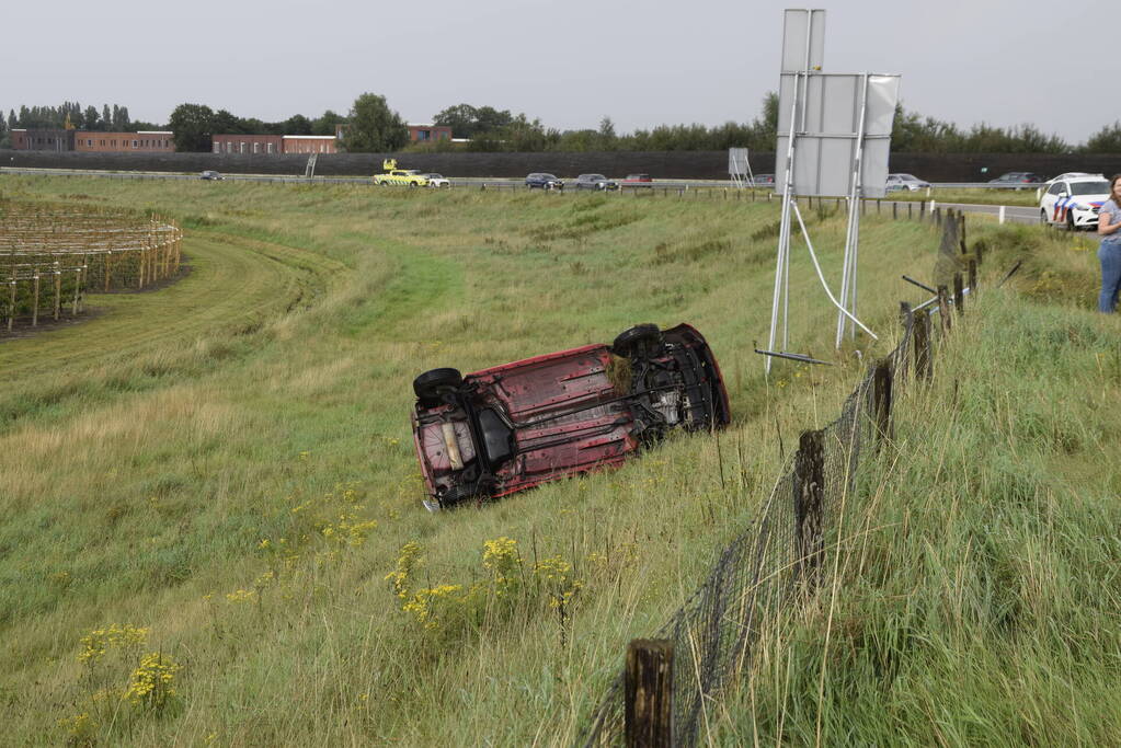 Automobilist belandt op zijkant naast afrit