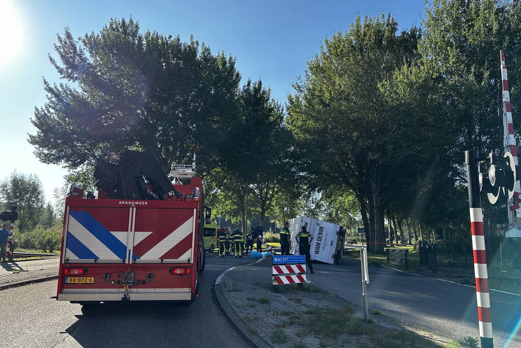 Vrachtwagen kantelt in bocht op overweg