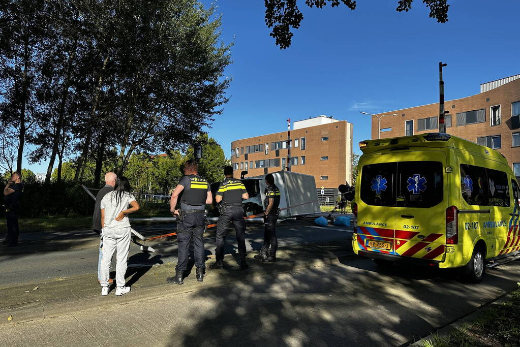 Vrachtwagen kantelt in bocht op overweg