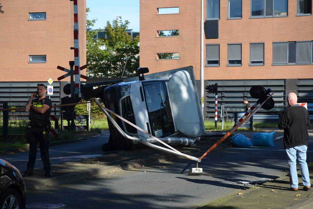 Vrachtwagen kantelt in bocht op overweg