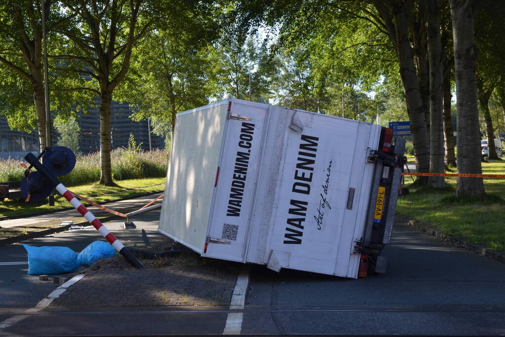 Vrachtwagen kantelt in bocht op overweg