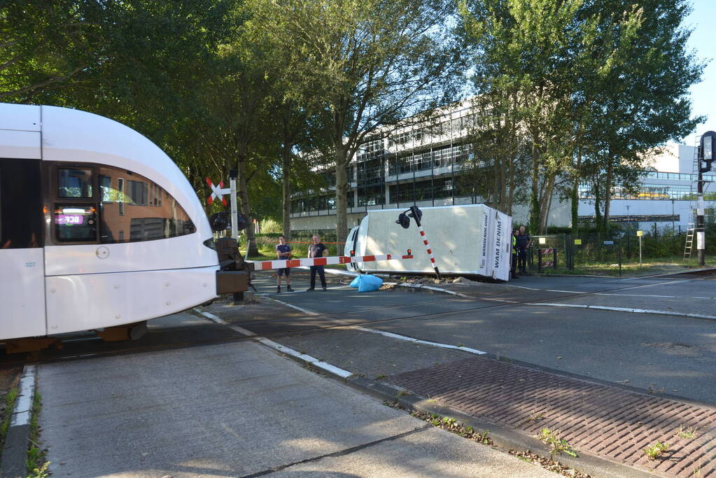 Vrachtwagen kantelt in bocht op overweg