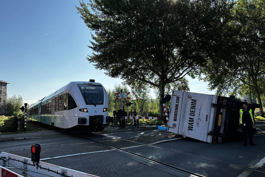 Vrachtwagen kantelt in bocht op overweg