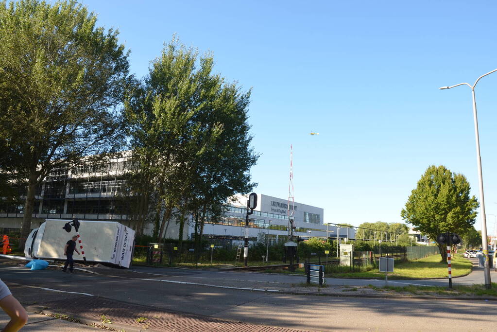 Vrachtwagen kantelt in bocht op overweg