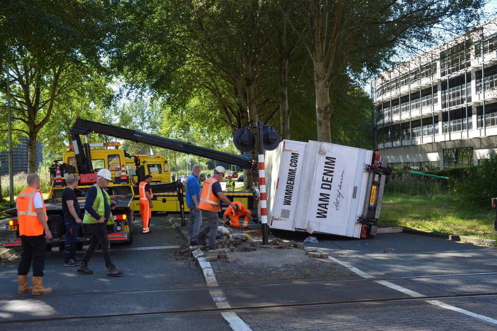 Vrachtwagen kantelt in bocht op overweg