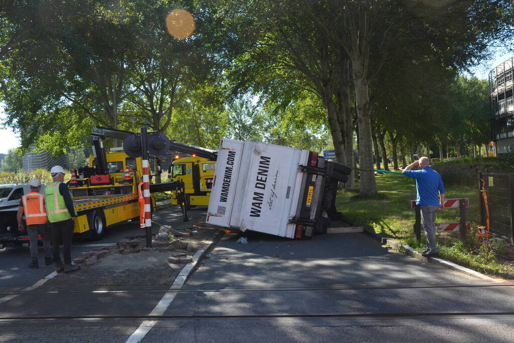 Vrachtwagen kantelt in bocht op overweg