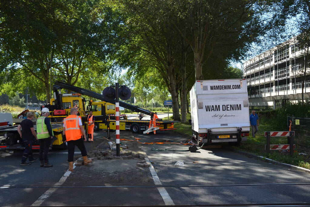 Vrachtwagen kantelt in bocht op overweg