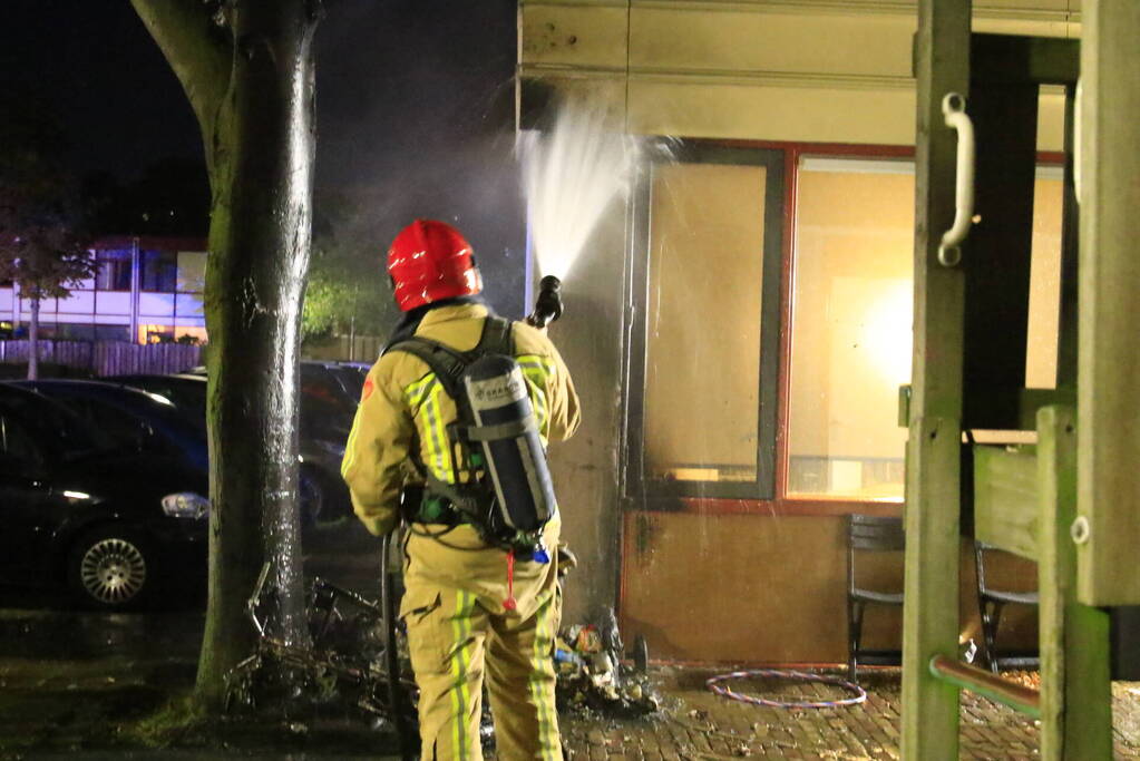 Scooter in brand tegen woning