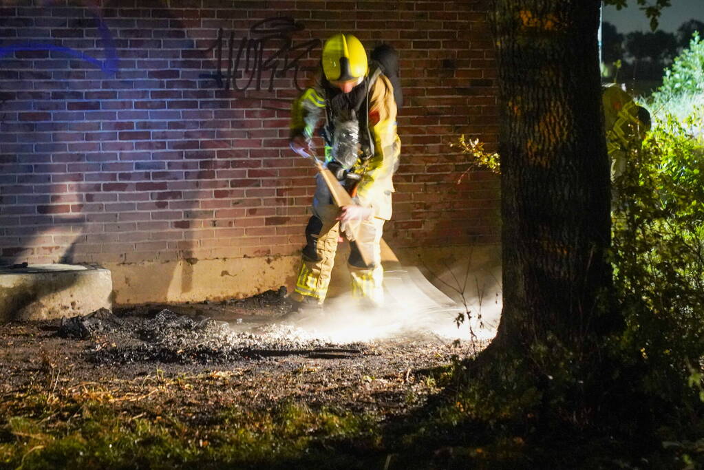 Bankstel tegen elektriciteitshuis in brand