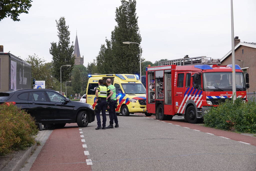 Scooterrijder bekneld onder auto