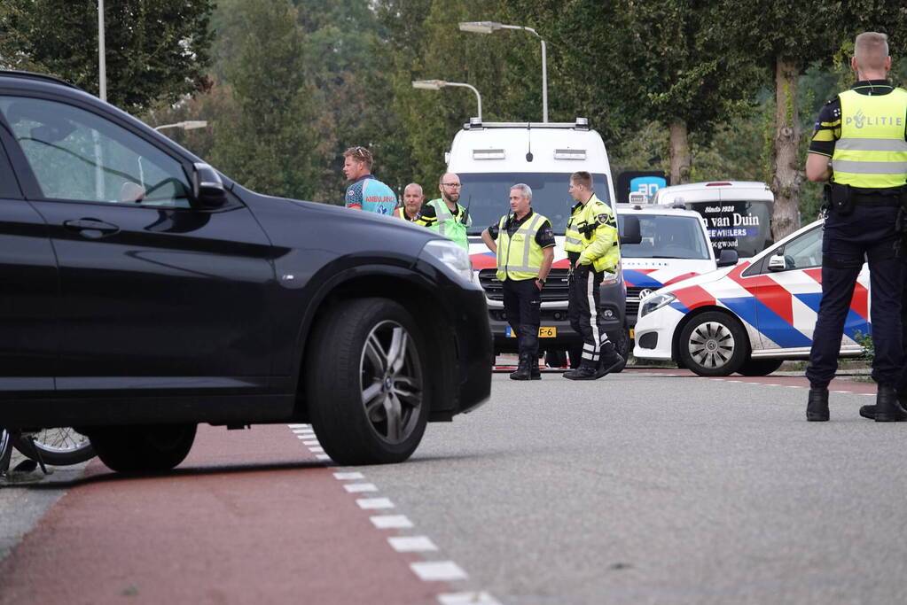 Scooterrijder bekneld onder auto