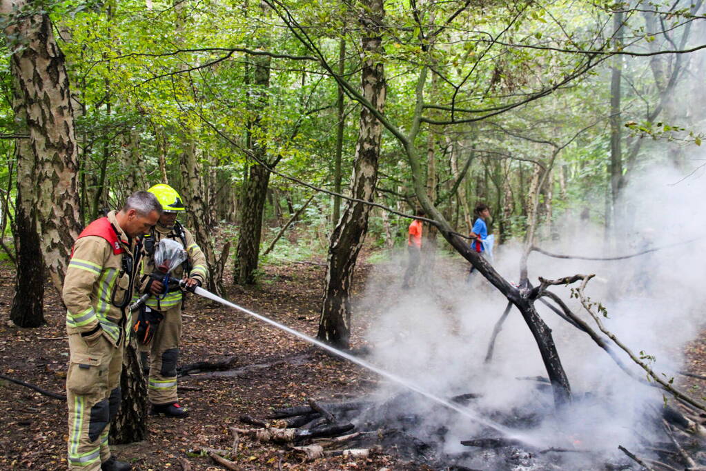 Brandweer blust kampvuur in bos