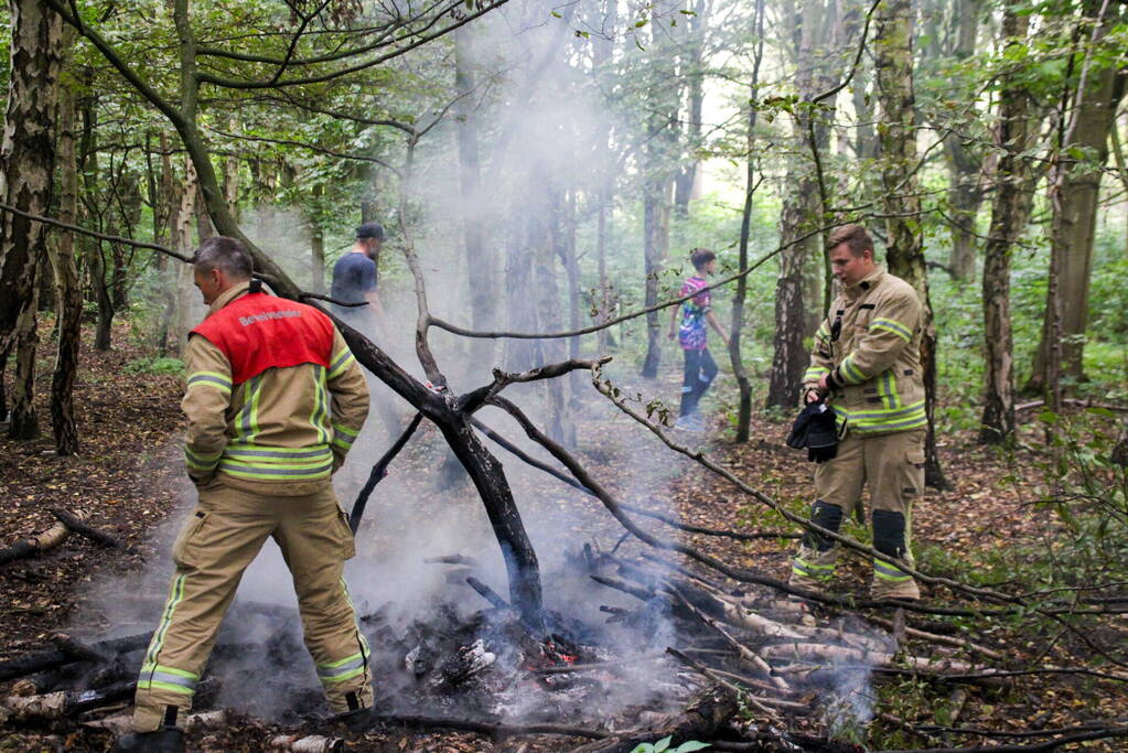 Brandweer blust kampvuur in bos