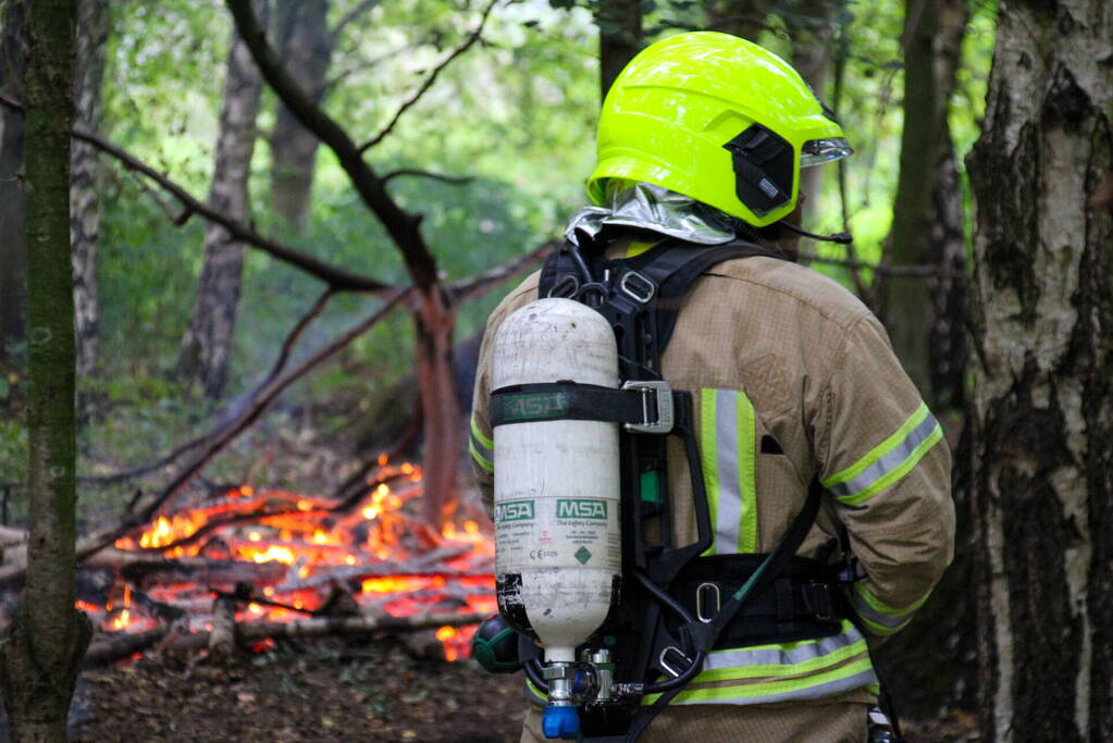 Brandweer blust kampvuur in bos